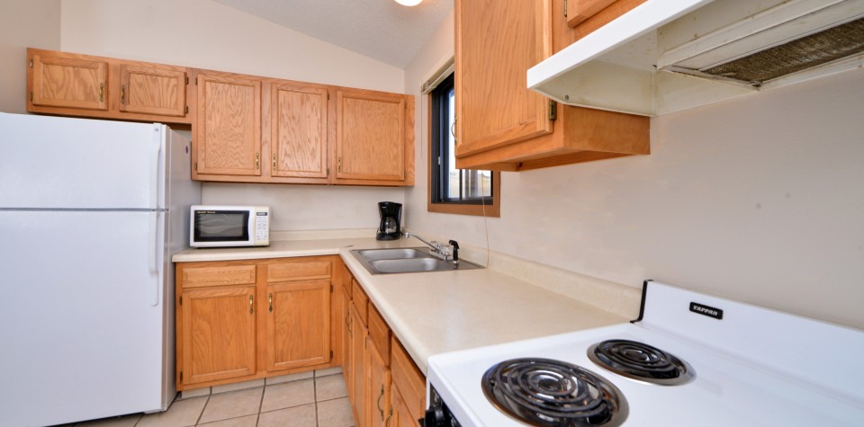 Kitchen with fridge, microwave, sink, coffee maker, and oven