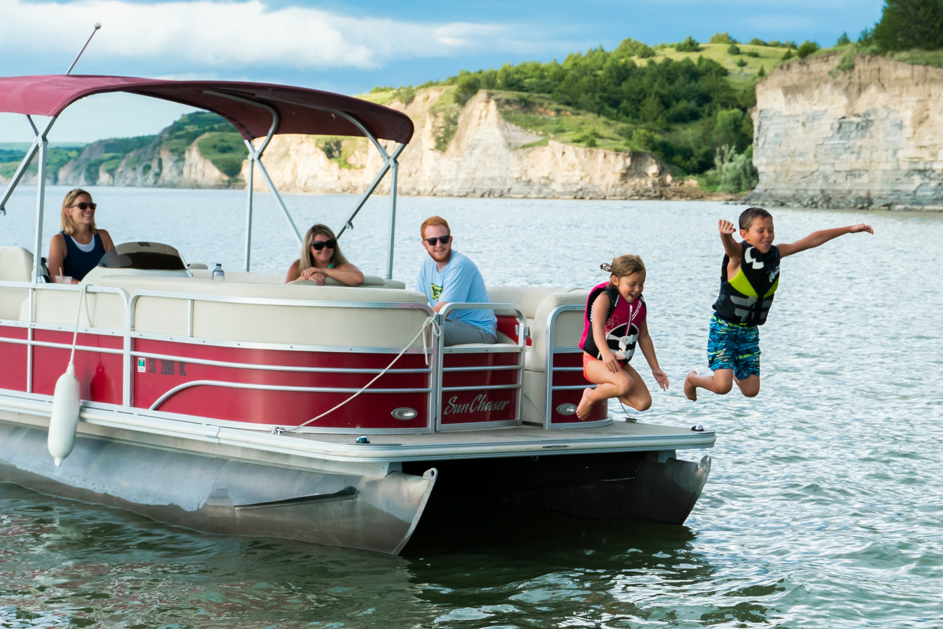A family having fun on a pontoon boat.